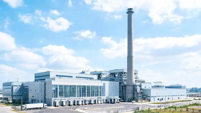 Extérieur d'une usine avec une cheminée, de jour